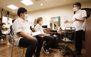 研修で始めた講話が評判を呼び、集まった多く人の前で話す店主・西村さん(右)=駅部田町のヘアスペースブルームで
