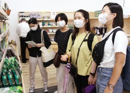 多気町を訪れ物産振興に関連した特産品などを見る学生ら=多気町五桂の五桂池ふるさと村で