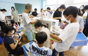3階から運んだ蔵書を棚に入れるなどする児童たち=嬉野川北町の豊田小で